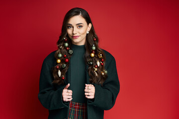 Joyful young woman showcases holiday spirit with ornaments in her hair and a warm smile.