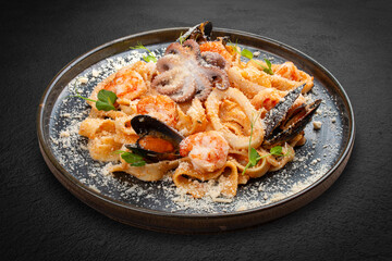 Tagliatelle with seafood in tomato-cream sauce. This Italian-inspired dish offers a delightful combination of textures and flavors from the sea.