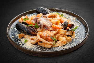 Tagliatelle with seafood in tomato-cream sauce. This Italian-inspired dish offers a delightful combination of textures and flavors from the sea.