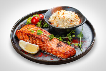 Salmon steak with creamy rice. A succulent salmon fillet, perfectly grilled or pan-seared, served alongside a bed of rich, creamy rice.