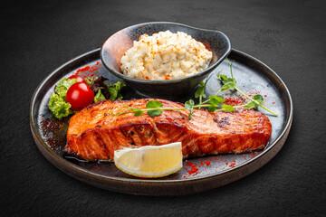 Salmon steak with creamy rice. A succulent salmon fillet, perfectly grilled or pan-seared, served alongside a bed of rich, creamy rice.