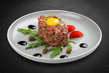 Fresh veal tartare served with tomatoes and arugula.