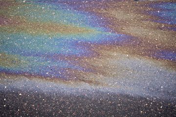 A bright oil slick with a whole range of bright colors on the asphalt surface.