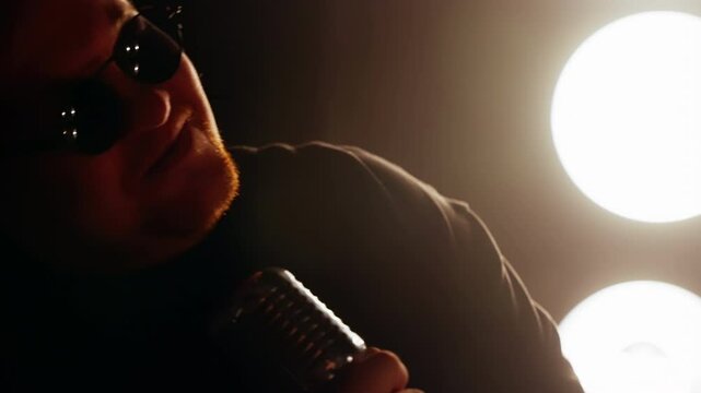 Male singer passionately performing into a vintage microphone on a brightly lit stage, surrounded by dynamic spotlights that amplify the vibrant energy of the moment