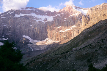 view of the snowy mountain peaks and cliffs during sunset