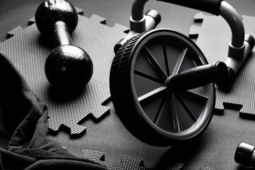 Exercise equipment on a black puzzle mat background.