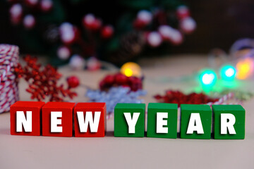 Calendar and new year concept. text of NEW YEAR on colorful wooden blocks with Christmas theme. colorful lights. 