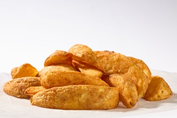 Close-up of golden and crispy potato wedges seasoned with spices.