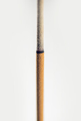 Closeup view of lighted incense stick for ritual, praying, or aromatic scented isolated over a white background