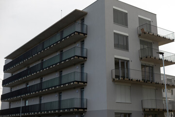 A large and impressive apartment building featuring numerous balconies and an abundance of windows,...