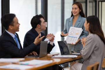 Asian businesswoman leader discussing business planning idea presentation with colleagues in conference room at office.