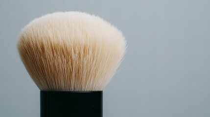 Close-up of a shaving brush with soft bristles on a pastel background.