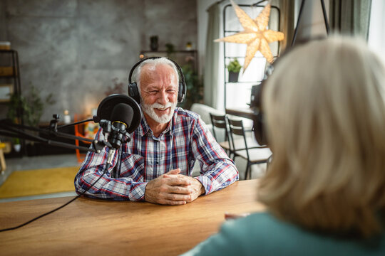 senior man host interviewer woman guest questions while record podcast