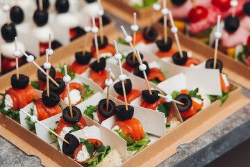 Catering table, beautifully decorated banquet with variety different food snacks appetizers on christmas corporate birthday party event or wedding celebration, canape, salad, delicatessen setting