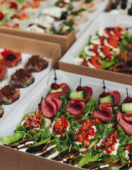 Catering table, beautifully decorated banquet with variety different food snacks appetizers on christmas corporate birthday party event or wedding celebration, canape, salad, delicatessen setting