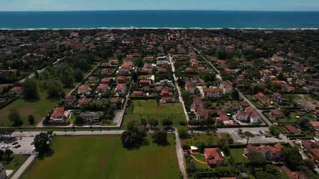 Drone aerial view of Forte dei Marmi village, beach and sea waves. Tuscany, Italy