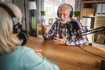 senior man host interviewer woman guest questions while record podcast