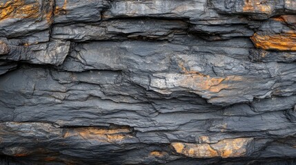 Textured Dark Slate Rock Surface with Orange Highlights and Layers