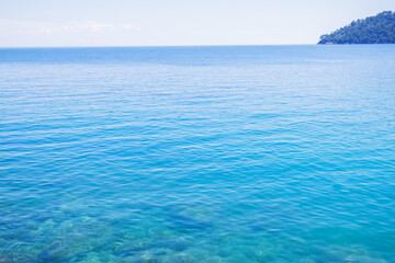 Fototapeta premium Breathtaking view of crystal-clear turquoise water gently lapping against a pristine shoreline.
