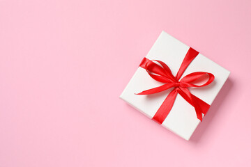 Beautiful gift box tied with bow on color background 