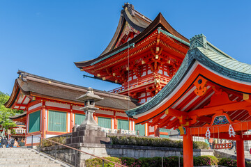The red traditional Japanese buildings stand out beautifully against the blue sky on the grounds of...