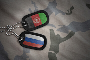 vintage army blank, dog tag with flag of afghanistan and russia on the khaki texture background....
