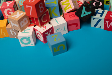 A colorful jumble of alphabet blocks on a bright blue background