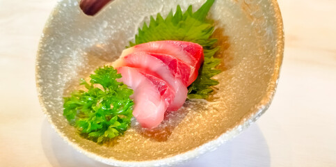 Snapper sashimi, raw fish in Japanese style, in beautiful bowl in restaurant