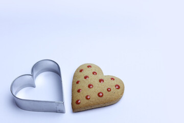 Gingerbread heart and cookie cutter on white background. Valentine's day concept.