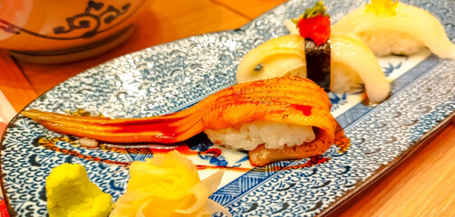 Anago, fresh sea eel, sushi on top with sauce in Japanese style in restaurant
