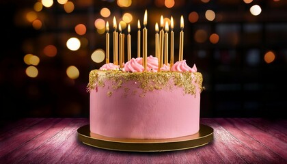 pink birthday cake with golden candles