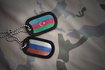 vintage army blank, dog tag with flag of azerbaijan and russia on the khaki texture background. military concept.