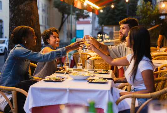 Friends toasting drinks at restaurant in lisbon, portugal