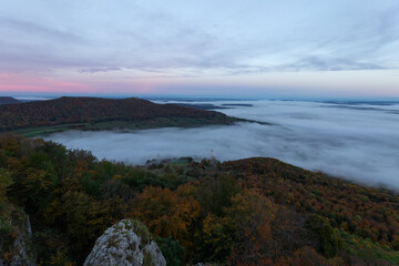 Obraz premium Kurz vor Sonnenaufgang auf dem Breitenstein. Burg Teck im Nebel. Herbststimmung auf der Schwäbischen Alb.