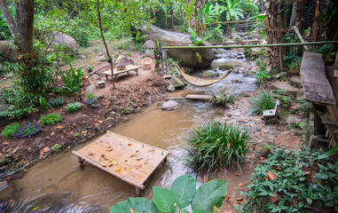 relaxing sitting area surrounded by a stream in a natural forest.