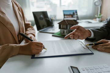 Client signing a real estate contract after listening to the realtor's explanation, with a...