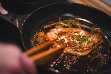 Mann brät sich ein Stück Fleisch zu Hause in der Pfanne