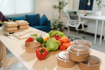 Workers preparing healthy food for delivery service in an office using biodegradable containers