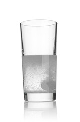 Tablet dissolving in a glass of water on white background