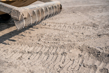 Selective focus on a raised root rake attachment on a skid steer construction equipment. 