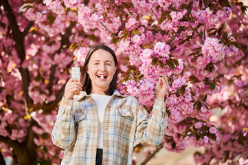 Woman allergic suffering from seasonal allergy at spring. Young happy woman applying allergy drug,...