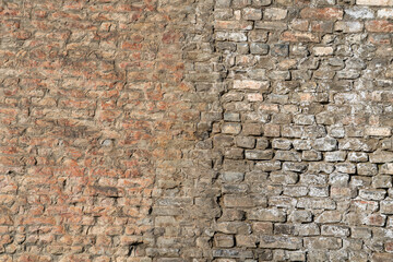 Damaged brick structure surface of the ancient city wall. Building part for texture, close-up.
