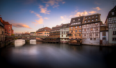 Obraz premium Beautiful reflections of traditional buildings on the river in Strasbourg during sunset