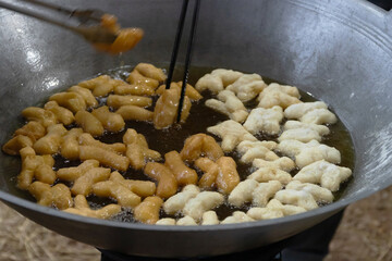 Chinese bread stick or chinese donut deep fry in a pan. Breakfast street food usually eat with hot tea, coffee or soy milk.