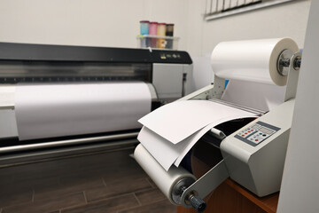 Modern roll laminator with paper on desk indoors. Printing house