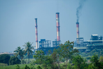 Obraz premium sugar mill, sugar factory in India, A sugar cane mill is a factory that processes sugar cane to produce raw sugar or plantation white sugar. Increasing air pollution to factory smoke.