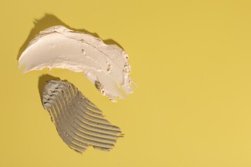 Samples of cosmetic products on yellow background, top view. Space for text