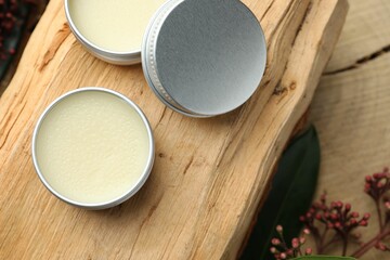 Natural solid perfume and skimmia plant on wood, top view