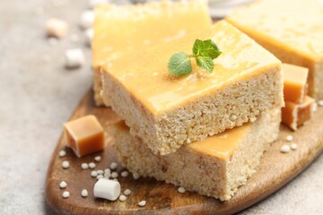 Delicious puffed rice bars, candies and mint on gray table, closeup