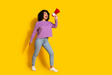 Full length portrait of pretty young girl loudspeaker empty space wear violet pullover isolated on yellow color background